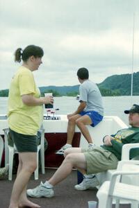 Shelly Hanson and Kurt Ristow converse while Eric Thompson looks out over the Mississippi River