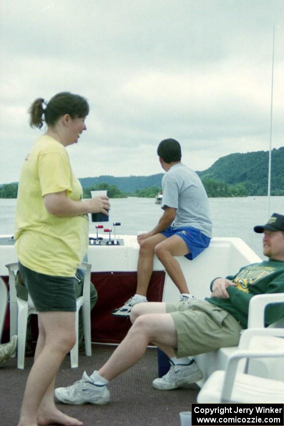 Shelly Hanson and Kurt Ristow converse while Eric Thompson looks out over the Mississippi River