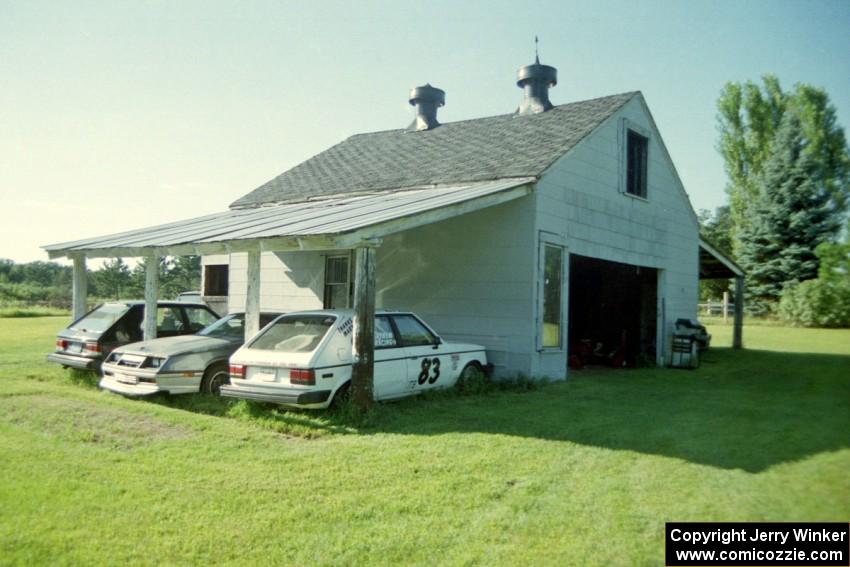 A Dodge Omni, a Dodge Daytona and ITB Dodge Omni next to the barn.