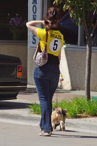 A fan of vintage cars walks her dog along the street.