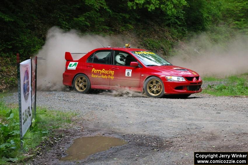 Bruce Perry drove the 0 car, a Mitsubishi Lancer Evo 8, for the day. The car is seen at a hairpin near the finish of SS6.