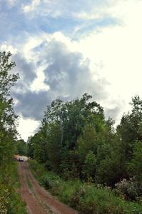 The Ken Block / Alex Gelsomino Subaru WRX STi rockets down a straight under gorgeous cloud-covered skies.