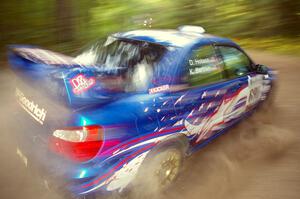 Kenny Bartram / Dennis Hotson Subaru WRX STi blasts gravel while taking a hard left-hander on the practice stage.