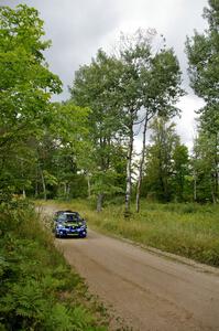 Ken Block / Alex Gelsomino Subaru WRX STi blasts down a straight as storm clouds approach from the west.