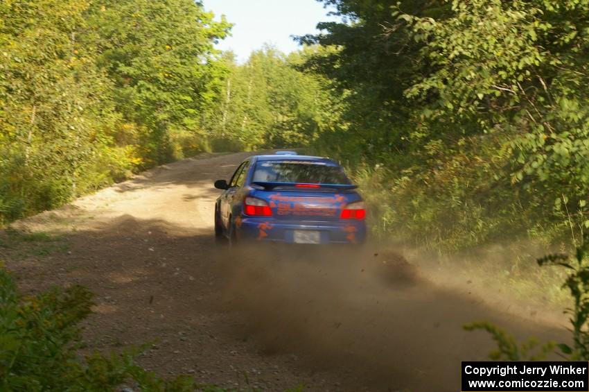 Tim Penasack / Scott Putnam drift through a uphill right-hander on the practice stage in their Subaru WRX.