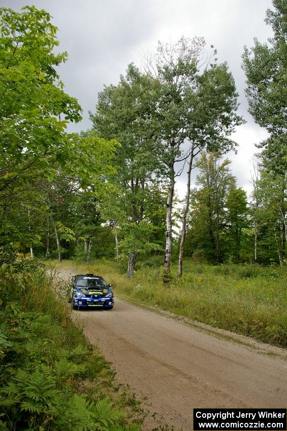 Ken Block / Alex Gelsomino Subaru WRX STi blasts down a straight as storm clouds approach from the west.