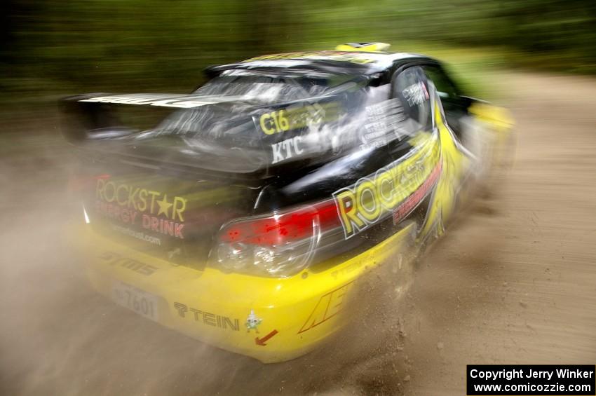 Tanner Foust / Chrissie Beavis Subaru WRX STi sprays gravel on the press stage.