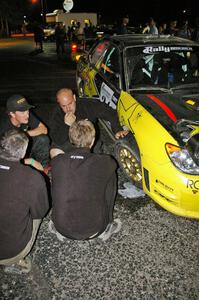 Andy Pinker and members of the SYMS crew assess the right-front suspension of the Tanner Foust/ Chrissie Beavis Subaru WRX STi.