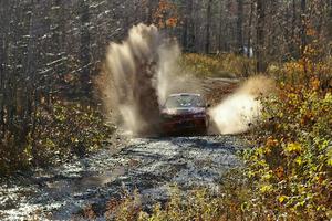 Dennis Martin / Kim DeMotte Mitsubishi Lancer Evo IV hits a puddle near the finish of Gratiot Lake 1, SS9.