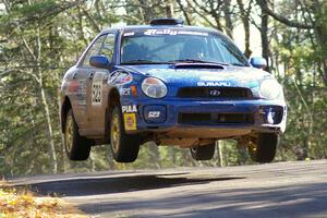 Travis Hanson / Terry Hanson Subaru WRX get nice air at the midpoint jump on Brockway Mountain, SS13.