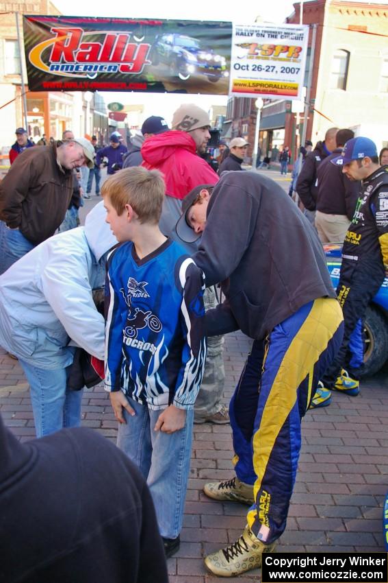 Travis Pastrana signs an autograph on the back of a young fan at parc expose in Calumet on Saturday of the event.