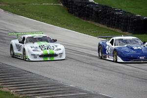 Rick Dittman's Chevy Corvette races past the stalled Jaguar XKR of Tomy Drissi