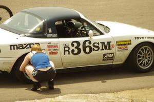 Samantha Silver checks the tires on her Spec Miata Mazda Miata