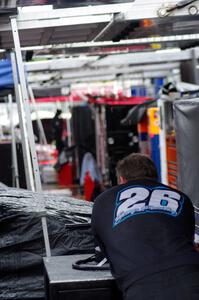 A crew member of Greg Pursley's team waits out the rain