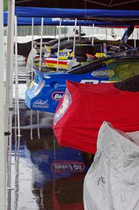 A continuous stream of rain water comes off of a canopy in paddock lane