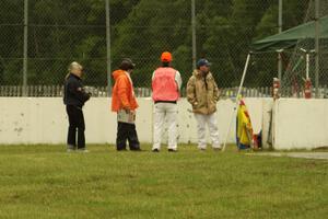 Corner workers at turn 12 watch cars at turn 6 on the pace lap