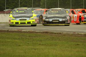 26) Greg Pursley's Ford Fusion and 03) Dylan Kwasniewski's Ford Fusion at the first turn