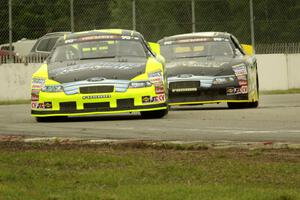 Greg Pursley's Ford Fusion and Dylan Kwasniewski's Ford Fusion at the end of lap one