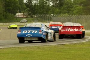 Daryl Harr's Chevy Impala and Brett Thompson's Chevy Impala at the back of a small pack at turn 6