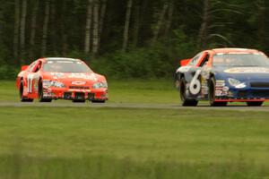 Derek Thorn's Ford Taurus and David Mayhew's Chevy Impala dive into turn three on the final lap