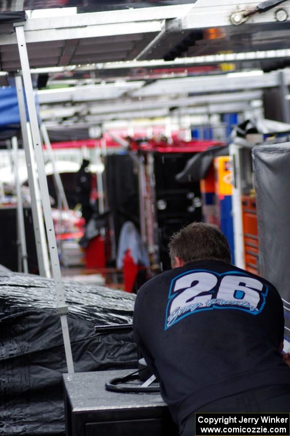 A crew member of Greg Pursley's team waits out the rain