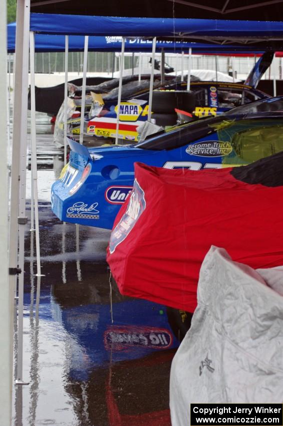 A continuous stream of rain water comes off of a canopy in paddock lane