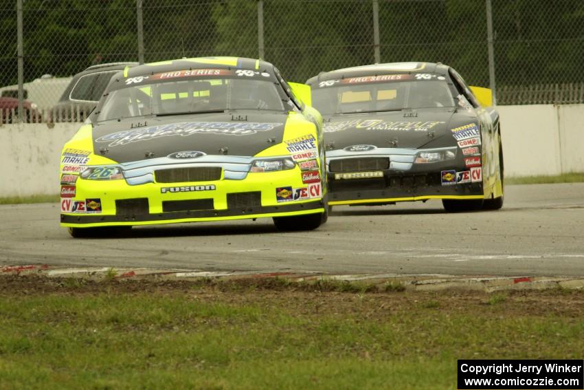 Greg Pursley's Ford Fusion and Dylan Kwasniewski's Ford Fusion at the end of lap one