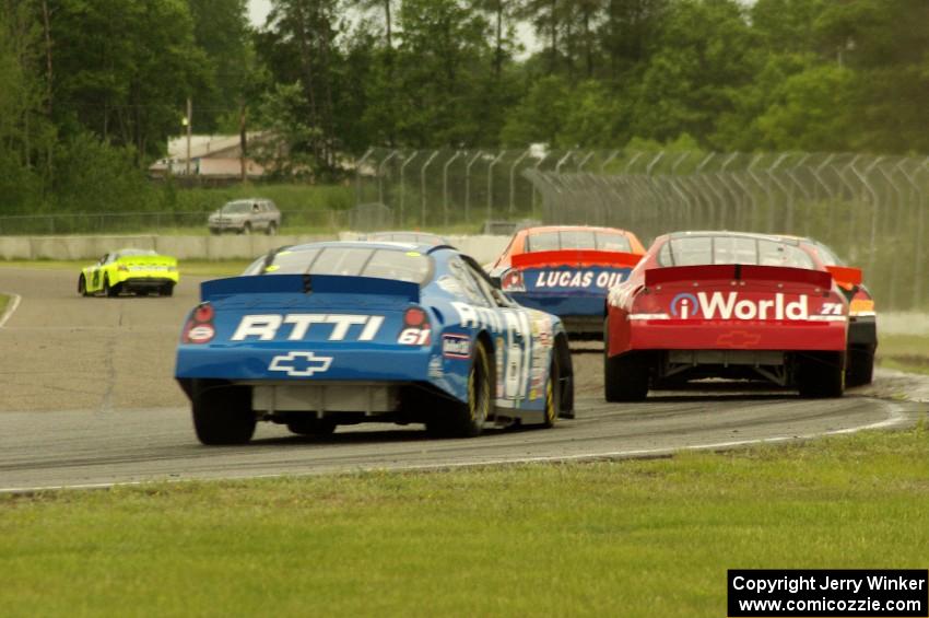 Daryl Harr's Chevy Impala and Brett Thompson's Chevy Impala at the back of a small pack at turn 6