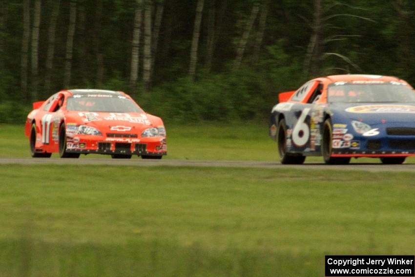 Derek Thorn's Ford Taurus and David Mayhew's Chevy Impala dive into turn three on the final lap