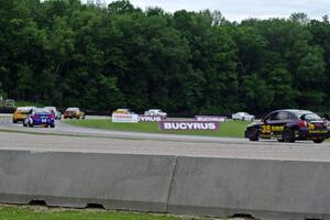 The field follows the pace car through the carousel during an early yellow.
