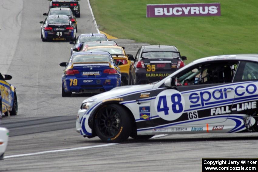 Charles Espenlaub / Charlie Putman BMW M3 Coupe spins as the GS field heads uphill from turn 5 on the first lap.