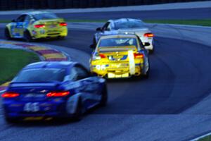 Nick Longhi / Matt Plumb BMW M3 Coupe leads three other GS cars through turn 6 near sundown.