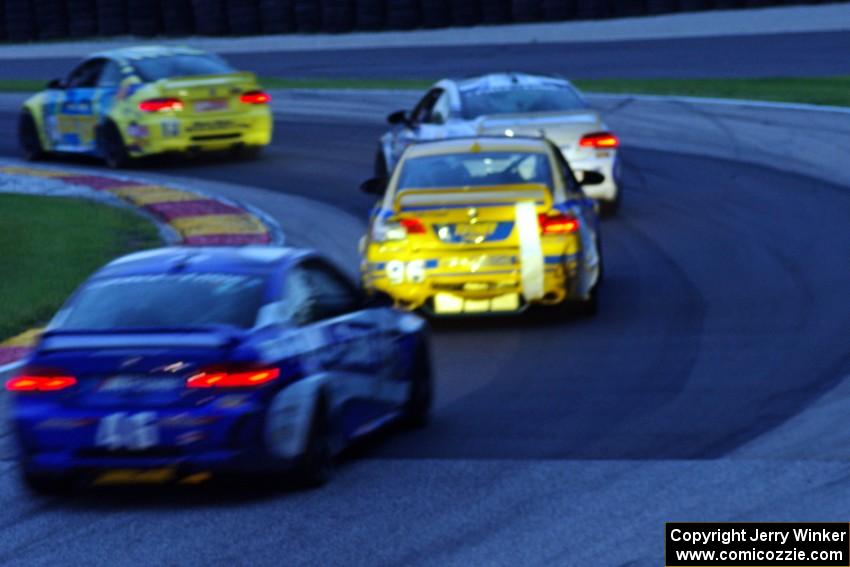 Nick Longhi / Matt Plumb BMW M3 Coupe leads three other GS cars through turn 6 near sundown.