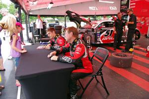 Dion von Moltke (L) and Jim Norman (R) sign autographs in front of their Audi R8.