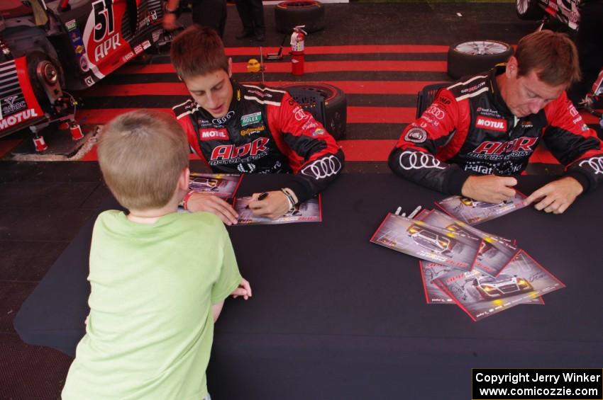 Dion von Moltke (L) and Jim Norman (R) sign autographs in front of their Audi R8.