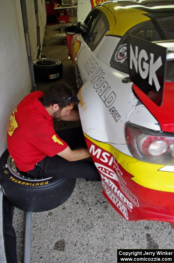 A crew member works on the Joe Nonnamaker / Will Nonnamaker Mazda RX-8.