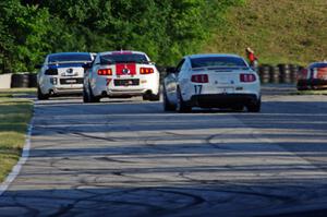 Three Ford Mustangs head into turn 7