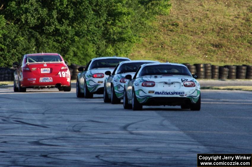 A Honda Civic Si and three Mazda MX-5s at turn 7