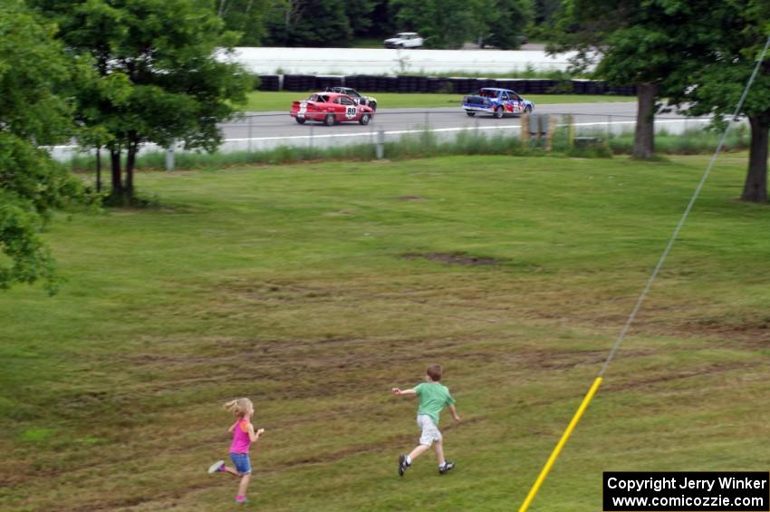 Kids drag race three cars as they dive into turn one