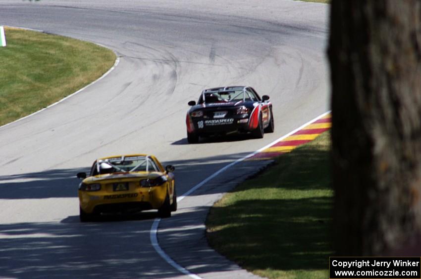 Dan Bender's and Ara Malkhassian's Mazda MX-5s head uphill through turn 13