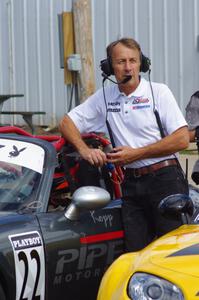 A series official leans against Kevin Kopp's Mazda MX-5