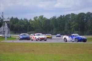 The Mazda MX-5 pack comes into turn 12 on the first lap