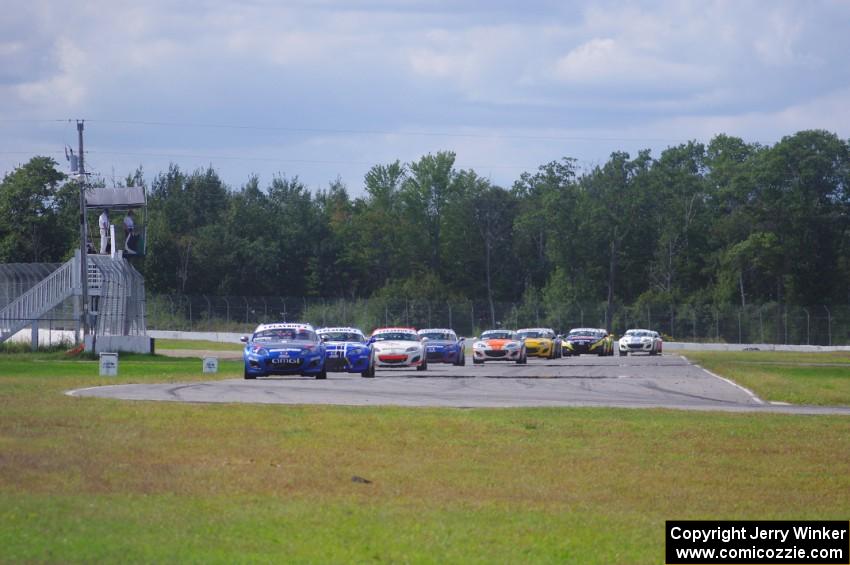 The Mazda MX-5 pack comes into turn 12 on the first lap