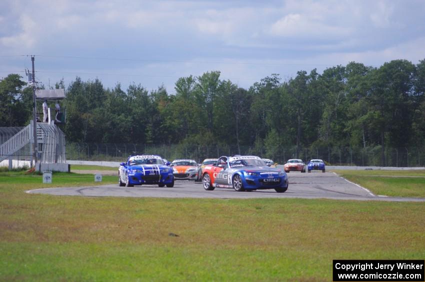 The Mazda MX-5 pack comes into turn 12 on the first lap