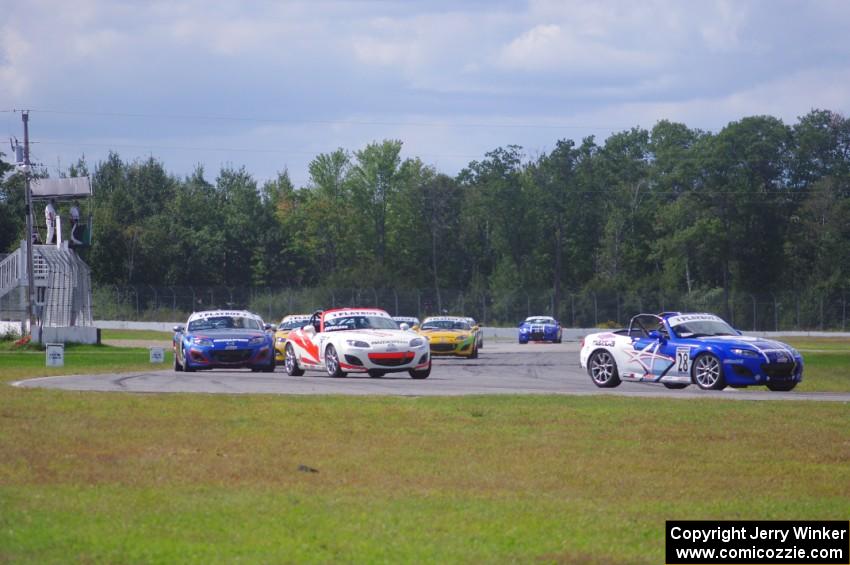 The Mazda MX-5 pack comes into turn 12 on the first lap