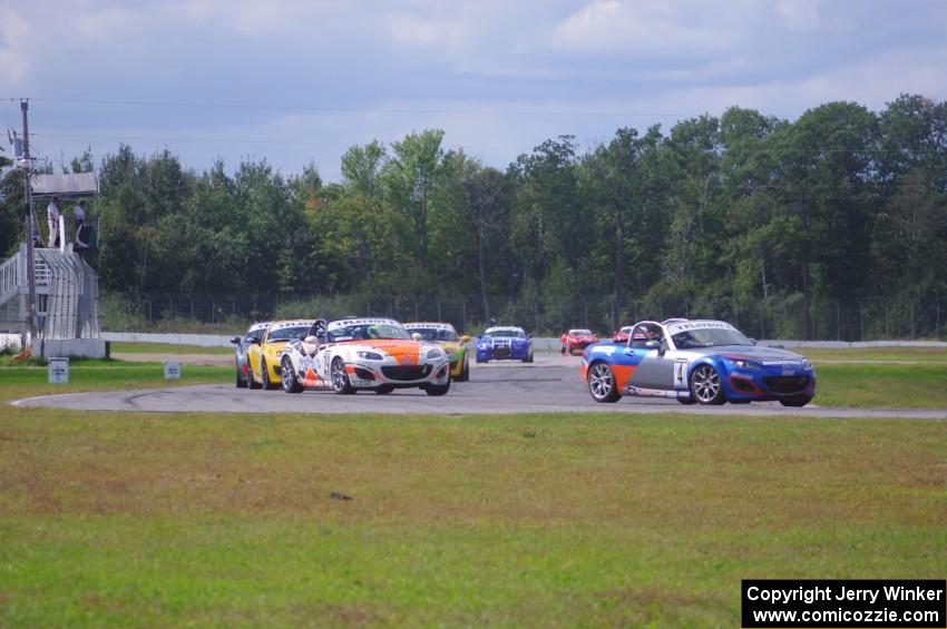 The Mazda MX-5 pack comes into turn 12 on the first lap