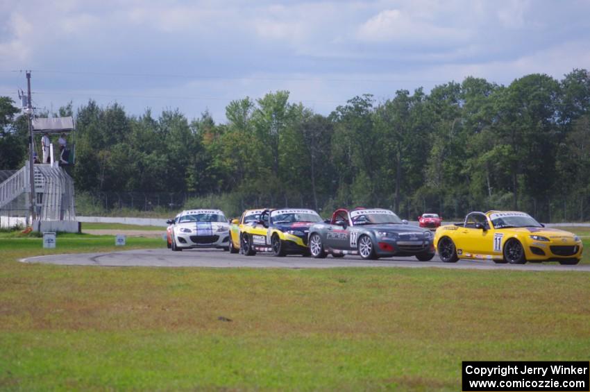 The Mazda MX-5 pack comes into turn 12 on the first lap