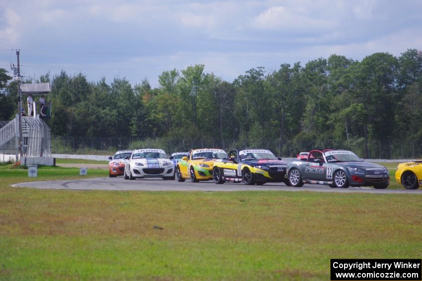 The Mazda MX-5 pack comes into turn 12 on the first lap