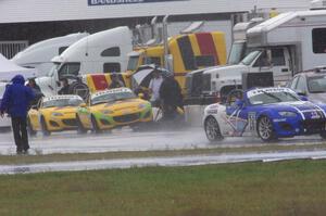 Jason Saini's Mazda MX-5 leaves the pits as Tim Probert and Ara Malkhassian get rain tires