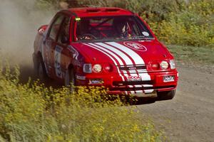 The Mike Whitman / Paula Gibeault Ford Sierra Cosworth at speed near the start of SS1.